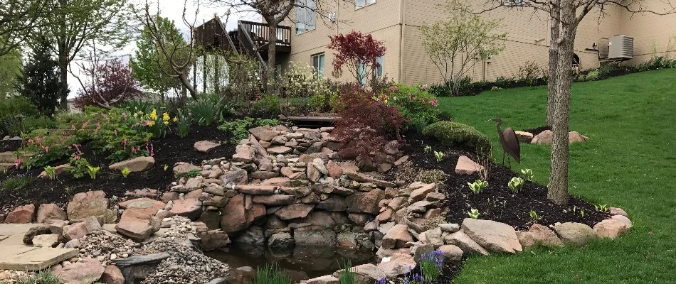 Grass and lush plantings around a water feature in Strasburg, PA.