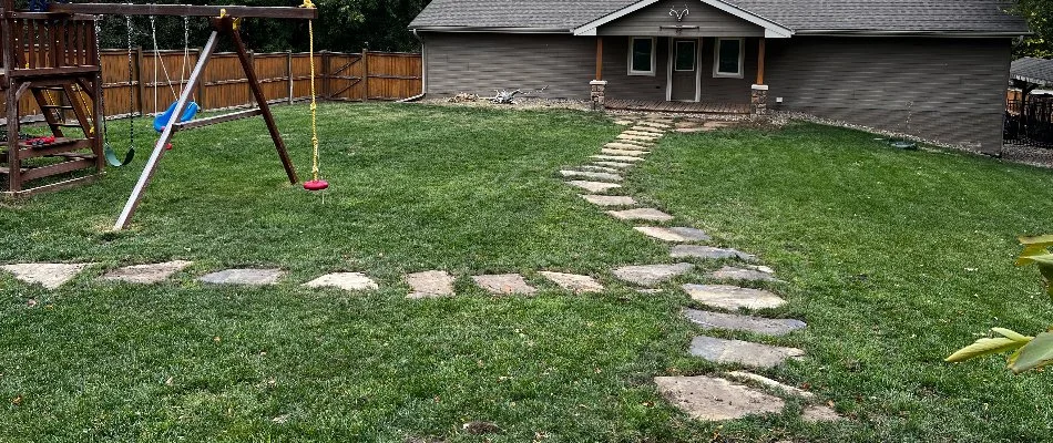 Healthy, fertilized lawn in Mountville, PA, with walkway and play area.